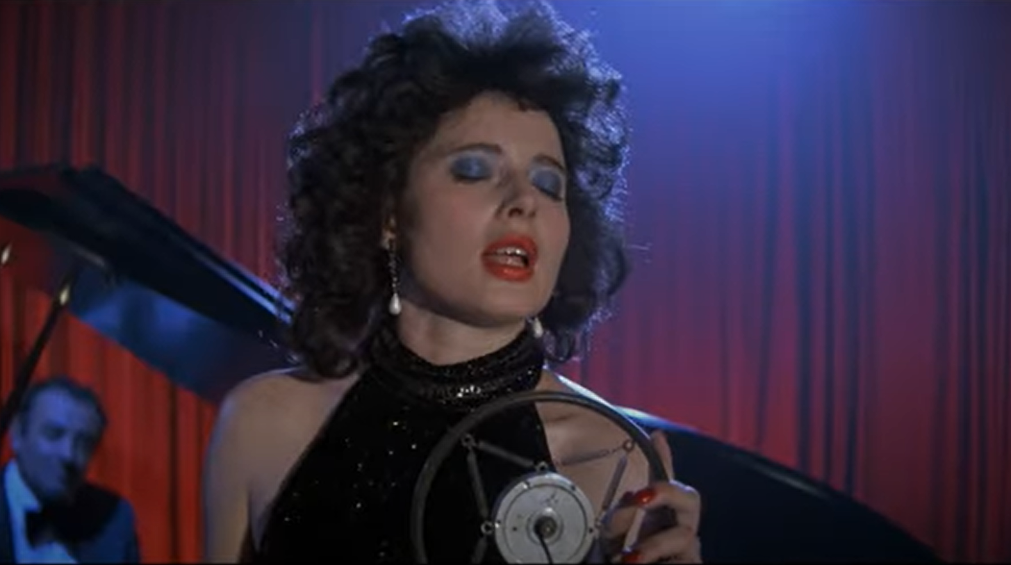 Dorothy Vallens (Isabella Rossellini), éclairée en bleu et rouge, chante sur scène au Slow Club, incarnation sensuelle et mélancolique de Blue Velvet.