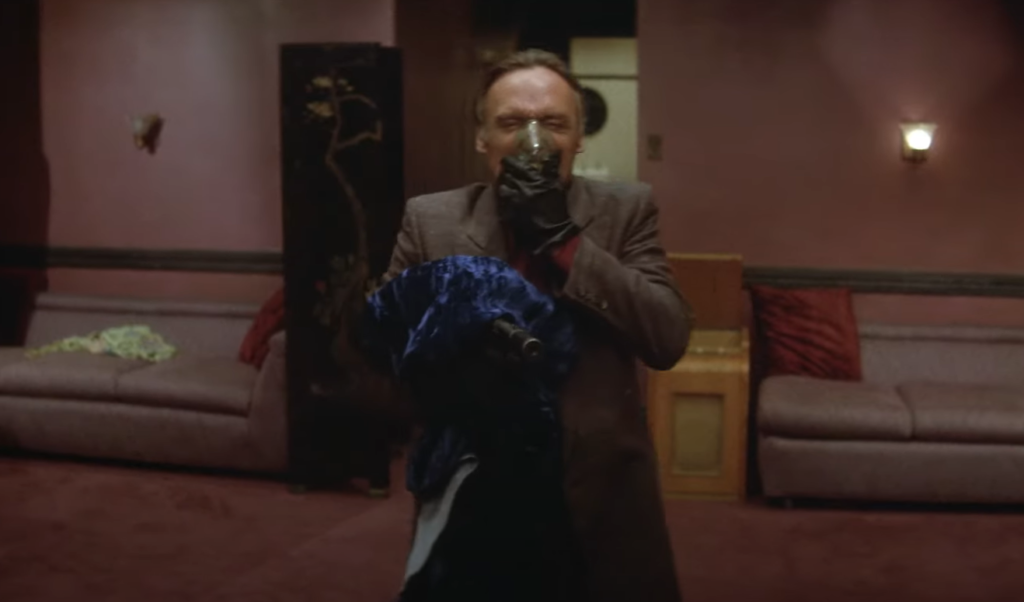Frank Booth (Dennis Hopper), tenant un revolver et utilisant son inhalateur, figure monstrueuse et imprévisible au cœur de Blue Velvet.