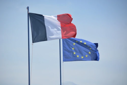 Drapeaux de la France et de l’Union européenne côte à côte, symbolisant la tension entre souveraineté nationale et projet européen.